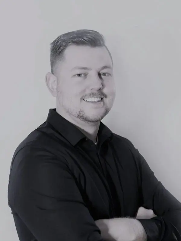 A man in black shirt smiling for the camera.