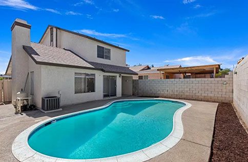 A pool that is in the middle of some houses.