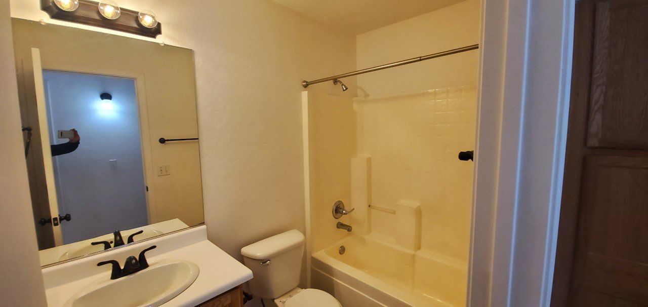 A bathroom with a sink, toilet and bathtub.