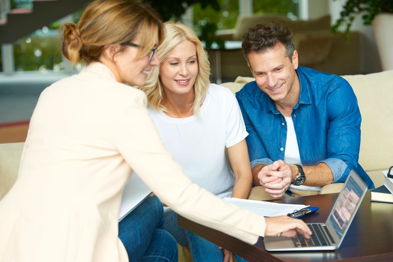 A woman showing two men something on the laptop.