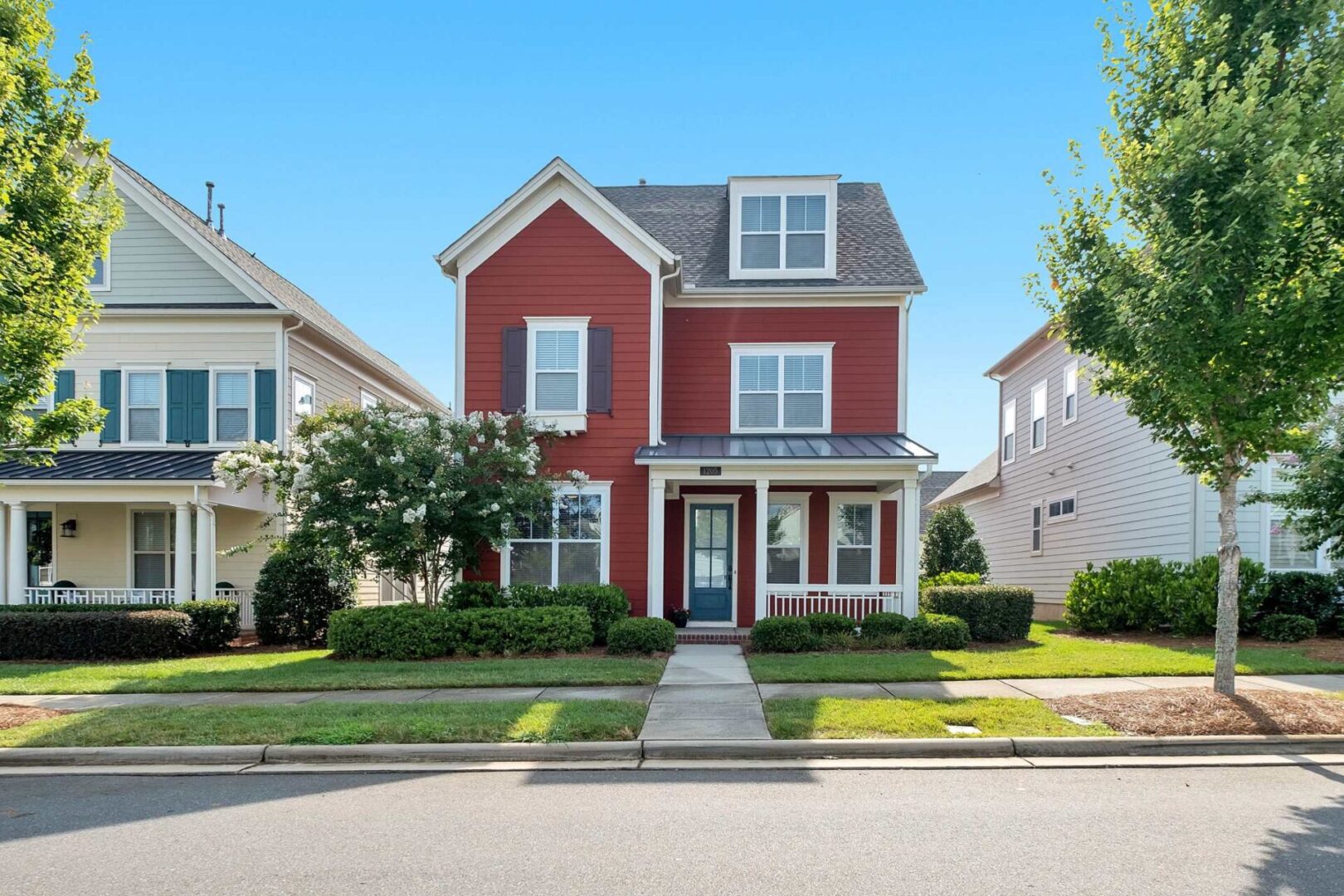 A red house with green shutters and a blue door.